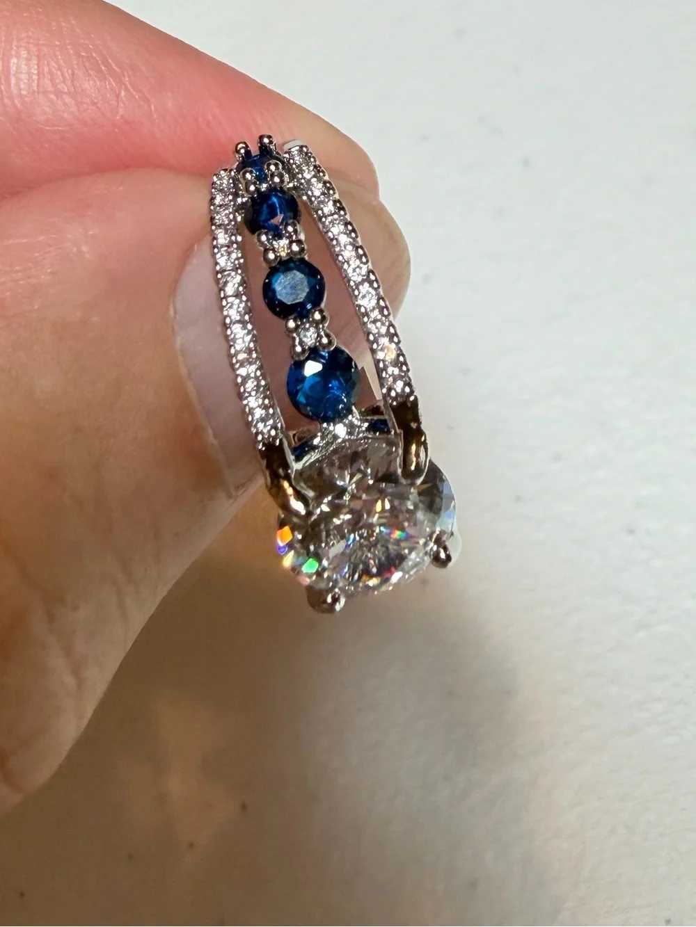 Silver Ring with Deep Blue Stones and Clear Center Gem.